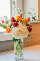 White, Pink and orange flower arrangement in a clear vase