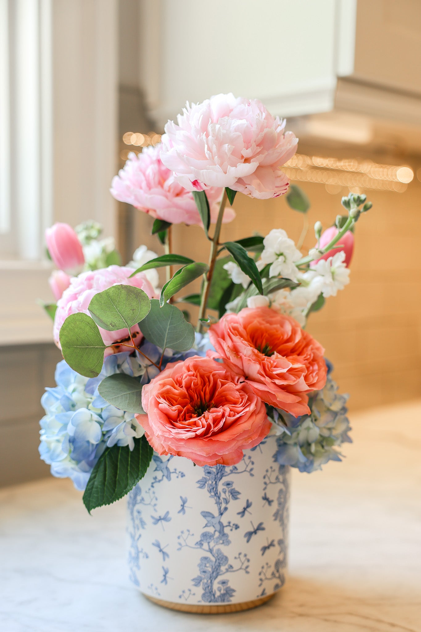 Pink and blue flowers in a blue and white vase