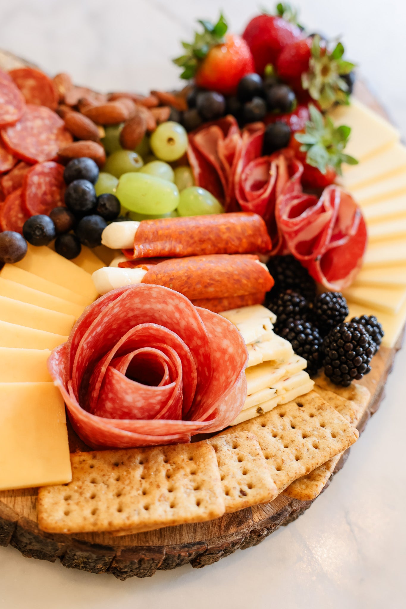 Charcuterie board with crackers, cheese, meats and fruits