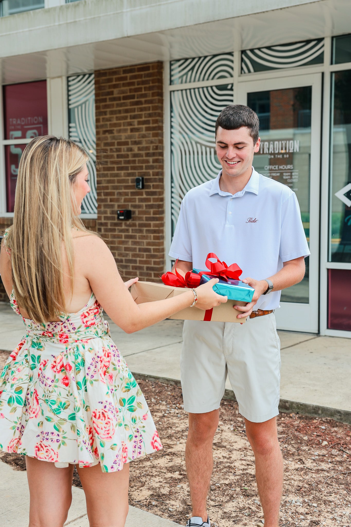 A girl delivering a charcuterie board and gift to a university of Alabama student on campus