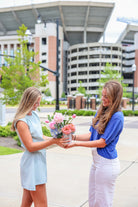 A girl delivering flowers to a University of Alabama student in front of Bryant Denny Stadium