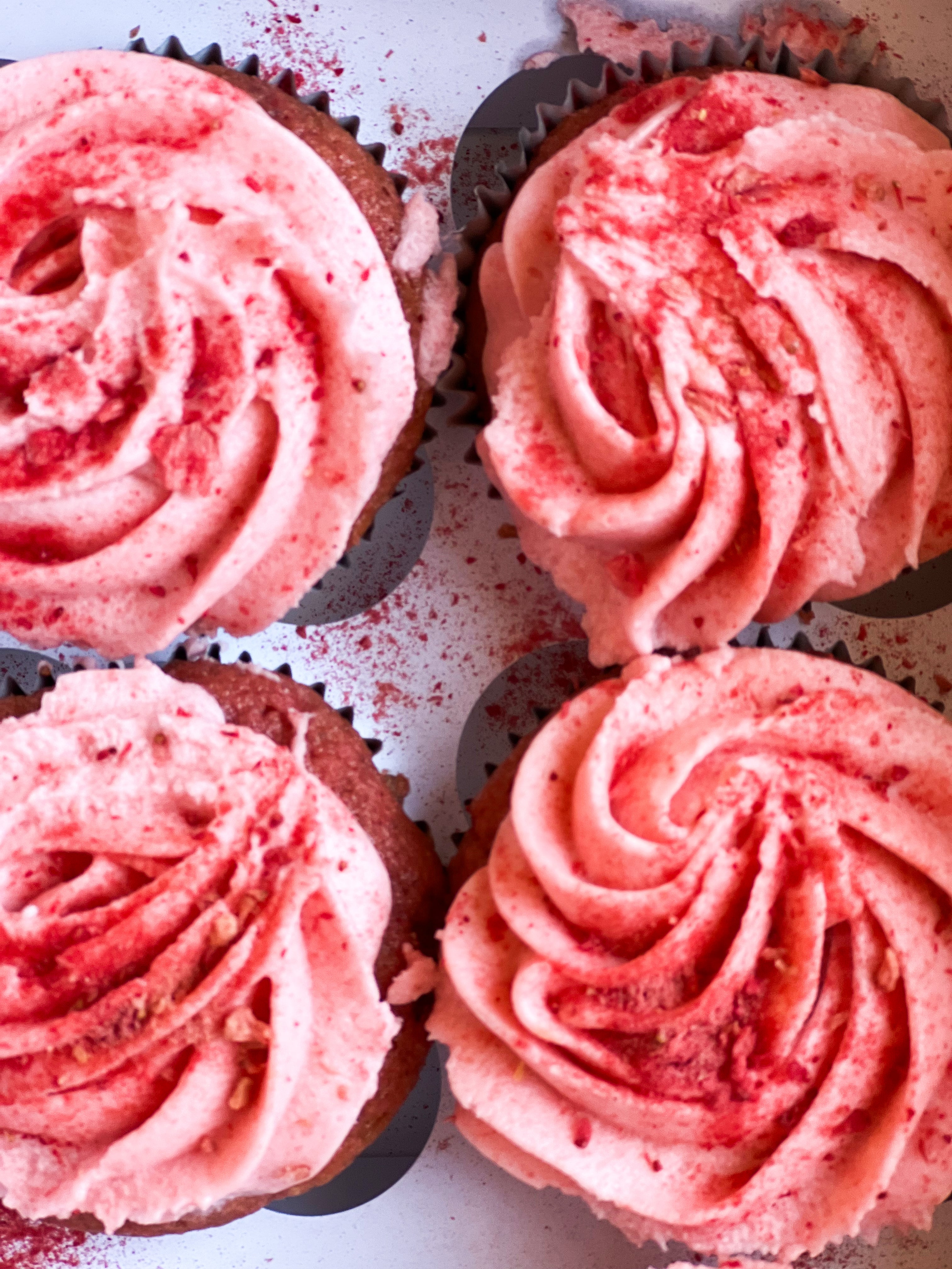 four pink cupcakes