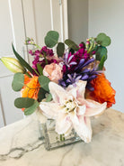 Colorful flower arrangement in a square clear vase