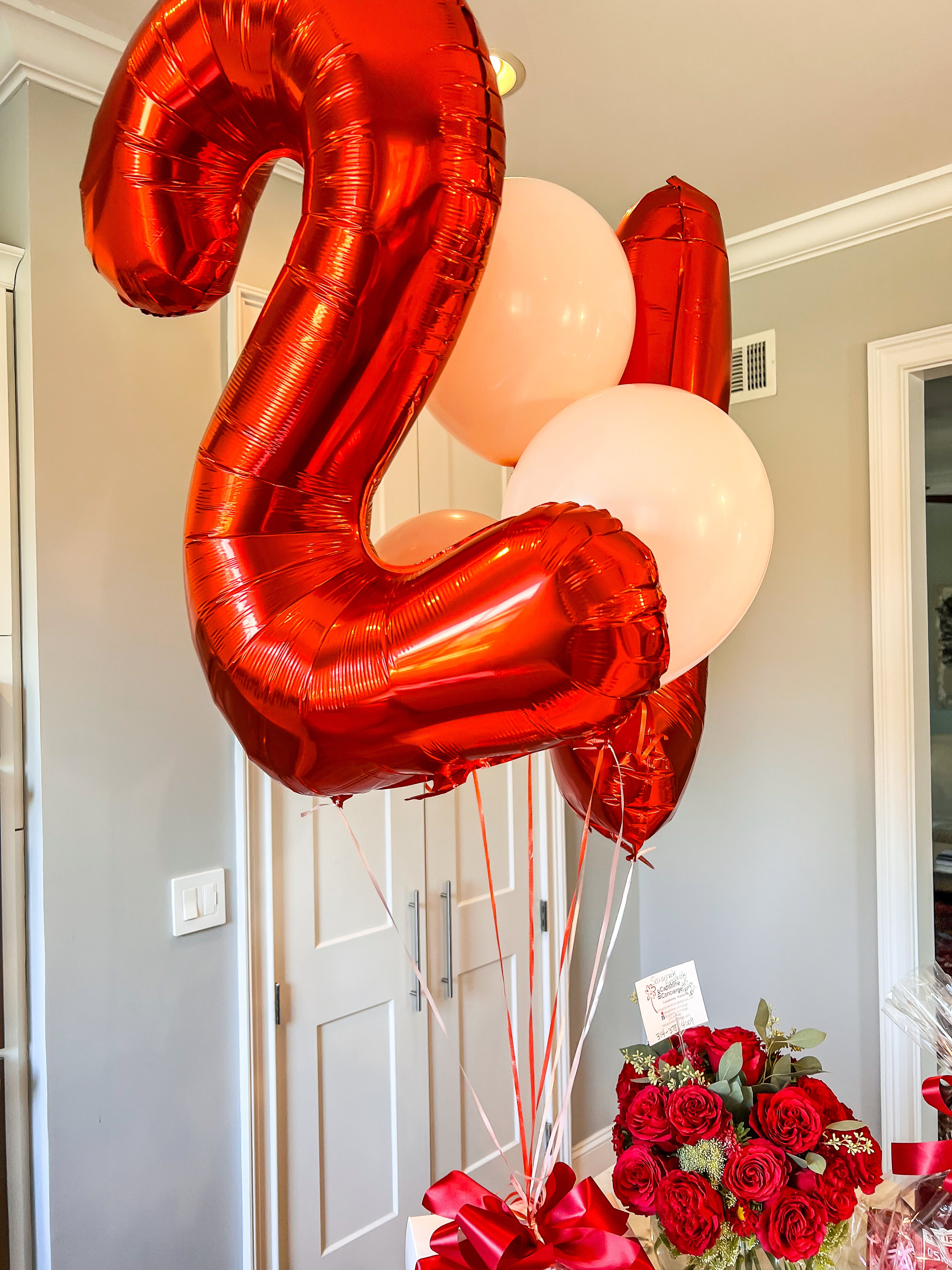 Jumbo red foil "21" balloons with white balloons and flowers also in the photo