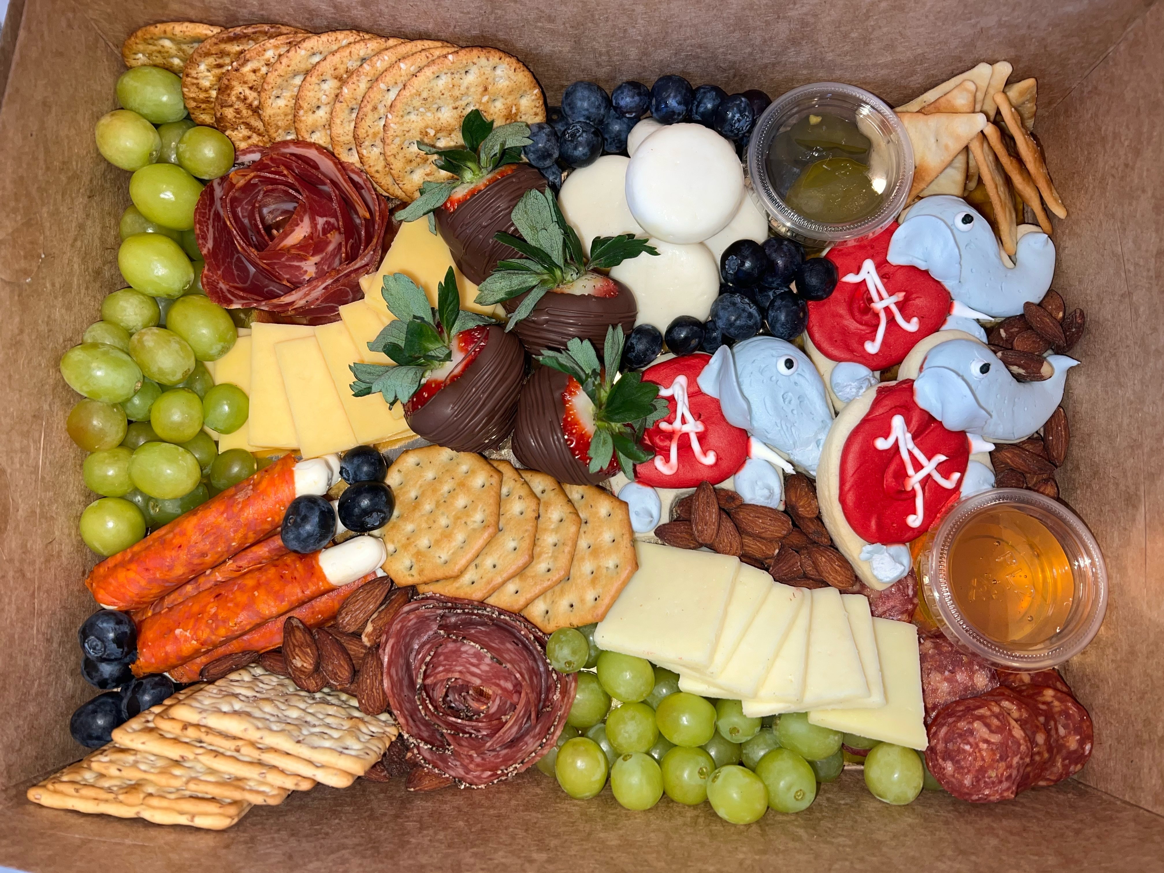 Alabama charcuterie board prepared for delivery with crackers, fruits, cheese, cookies