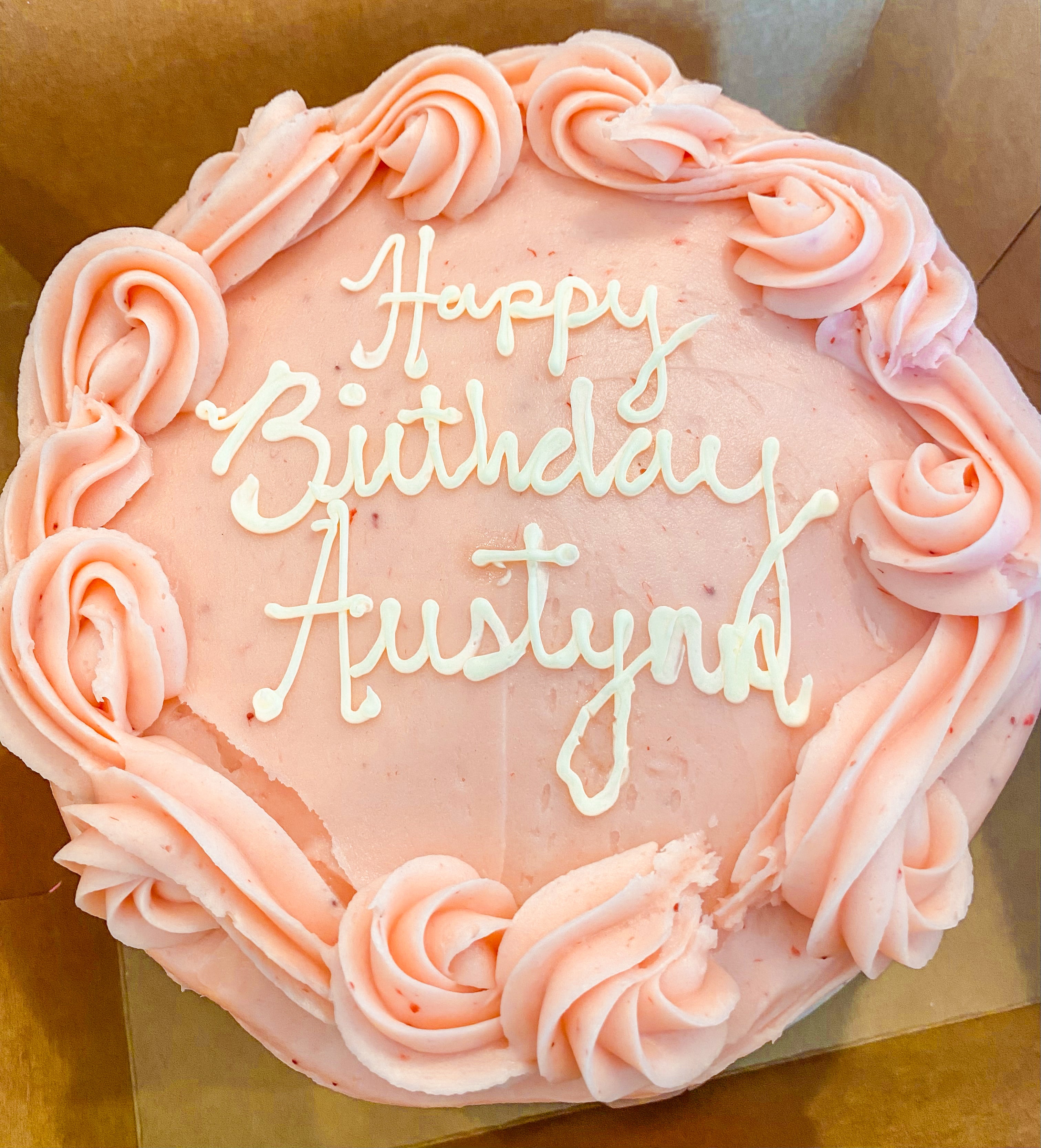 Cake with pink icing that says "Happy birthday Austin!"